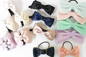 ヘアアクセサリー・生地物シリーズの商品を並べた写真。くすみ色や淡い色のリボン結びの飾りを並べたもの